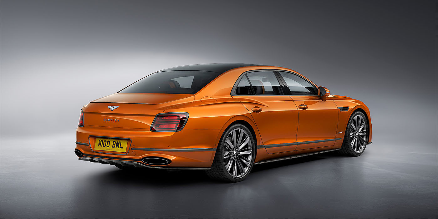 Bentley Madrid Bentley Flying Spur Speed in Orange Flame colour rear view, featuring Bentley insignia and enhanced exhaust muffler.