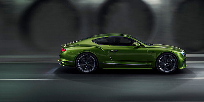  Bentley Madrid Bentley Continental GT coupe in Tourmaline Green paint driving in profile on a dark road